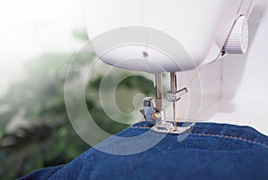 Close up sewing machine sew seam of blue denim jean