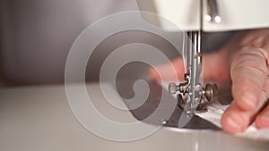 Close up of sewing machine with women's hands on table. Woman stitching curtain, using sewing machine.