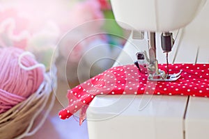 Close up of sewing machine working with red fabric