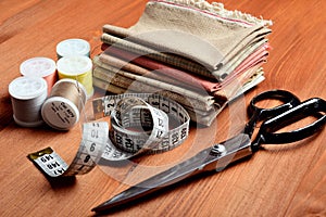 Close-up sewing tools on wooden background, vintage style