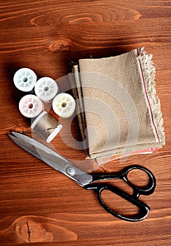 Close-up sewing tools on wooden background, vintage style