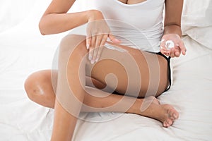 Close up of sexy woman applying body lotion photo