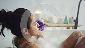 Close up sexy woman bathing at luxury home. Relaxed girl lying in foam bath.