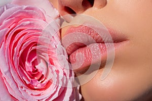 Close up sexy woman natural lips and beautiful red rose. Lips with lipstick closeup. Beautiful woman lips with rose.