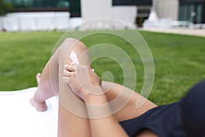 Close up of sexy young woman on the beach applying sun cream