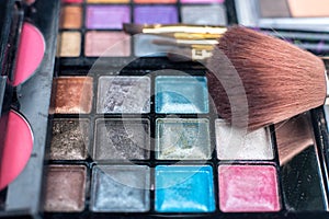 Close up shadow kit with brushes for make-up. beauty background.