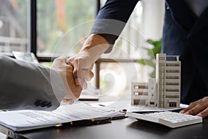 Close up shake hands, Considering buying a home, investing in real estate. Broker signs a sales agreement. agent, lease agreement