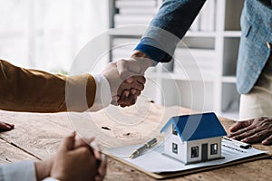 Close up shake hands, Considering buying a home, investing in real estate. Broker signs a sales agreement. agent, lease agreement