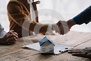 Close up shake hands, Considering buying a home, investing in real estate. Broker signs a sales agreement. agent, lease agreement