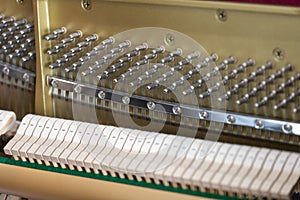 Close-up shallow focus image of the internal mechanisms of an upright piano. It gives a feeling of luxury, beauty, classic,