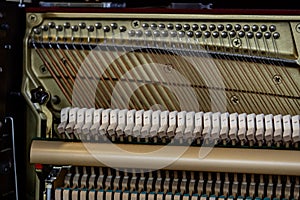 Close-up shallow focus image of the internal mechanisms of an upright piano. It gives a feeling of luxury, beauty, classic,