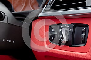 Close-up, shallow focus of a switch control for headlights and fog lights as seen on the dashboard of a german made sports car