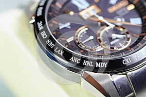 close up shallow focus Time zone cities code on luxury world time watch bezel on DEN Denver, LAX Los Angeles