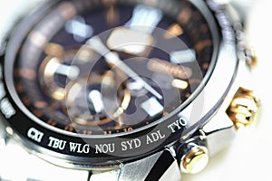 close up shallow focus Time zone cities code on luxury world time watch bezel on SYD Sydney, ADL Adelaide, NEU Neumea, TYO Tokyo photo