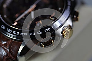 close up shallow focus Time zone cities code on luxury world time watch bezel, SYD Sydney, ADL Adelaide, NEU Neumea, TYO Tokyo photo