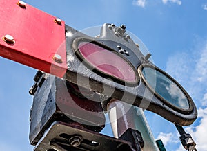 Close-up, shallow focus view of a vintage railway signalling system showing the coloured glass.