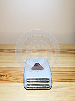 CLOSE-UP OF SHAVER ON WOODEN TABLE