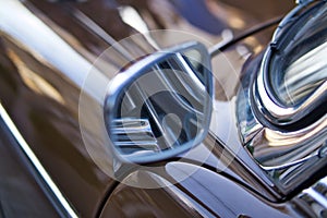 Close up of shiny chrome rear view mirror of classic car