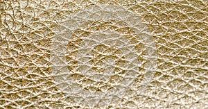 Close up on shiny gold faux leather texture.