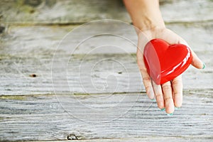 Close up of shiny red heart in young womanâ€™s hands, charity concept