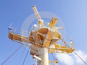 Close up of ship's communication and floodlight system on mast. Marine navigation concept, yellow metal mast