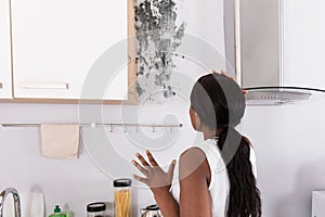 Shocked Woman Looking At Mold On Wall photo
