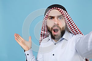 Close up of shocked young arabian muslim man in keffiyeh kafiya ring igal agal casual clothes isolated on pastel blue