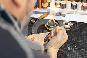 Close up of a shoemaker or artisan worker hands. Leather craft tools on old wood table