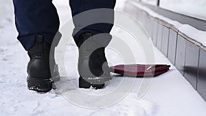 Close-up, shoes and snow on the street in winter, loss and loss of a wallet, distraction and not being attentive. Lose