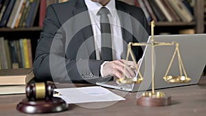 Close up Shoot of Judge Hand using Laptop and Notes in Court Room