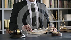 Close up Shoot of Lawyer Hand Reading Book on Court Room Table