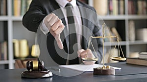 Close up Shoot of Lawyer Hand showing Thumbs Down in Court Room