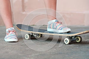 Close up shoot of sneakers on skateboard in casual style in summer day on the street