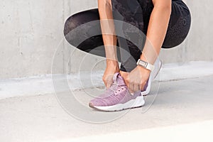 Close up shoot of woman`s hands tying the shoelaces of sporty sneakers. Fitness sporty woman is preparing for running