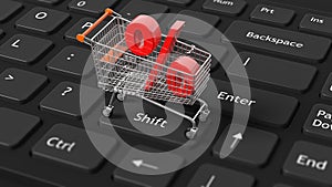 Close-up of shopping cart with red percent symbol on keyboard