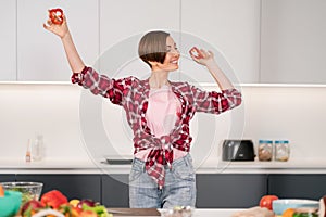 Close up. Short hair woman in red shirt playing with food, cut slices of sweet paper while cooking in the white kitchen