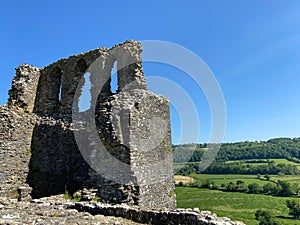 Close-up shot of ancient Dryslwyn Castle with lush green trees landscape in the backdrop