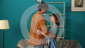 Close up shot of apartment living room. Man and woman dancing in the new apartment room, happy expression, positive mood