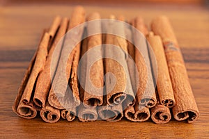 Close up shot of aromatic dry cinnamon sticks on wooden table background, Selective focus