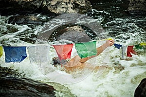 Spiritual man swims by tibetan flags