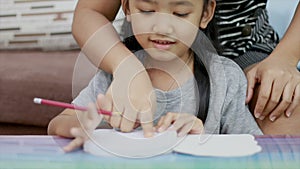 Close up shot Asian little girl doing homework and her mother teach