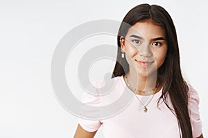 Close-up shot of attractive young and friendly indian teenage girl with earrings and necklaces smiling cute at camera as