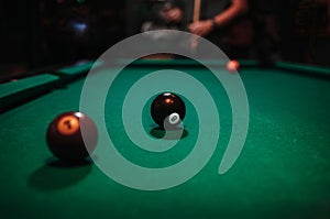 Close-up shot of balls on a pool table with a person in background