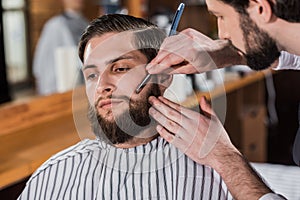 close-up shot of barber shaving man