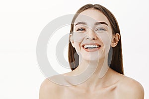 Close-up shot of beautiful and happy young charming girlfriend posing naked laughing and smiling gazing at camera as if