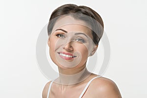 Close-up shot of beautiful mid adult woman smiling on white background.