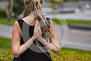 Close-up shot of beautiful woman with blonde hair doing yoga exercise in green public park in summer morning, outdoors
