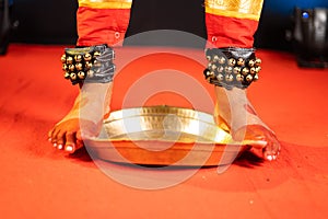 Close up shot of bharatnatyam kuchipudi artist dancing by balancing on edge of brass plate - concept of professional