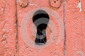 Close-up Shot Of A  Big Keyhole On A Wooden  Door  painted red