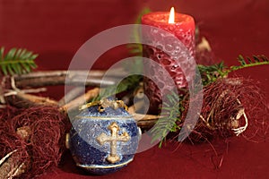 close-up shot, blue Christmas tree ball decoration, with golden cross and a red candle in front of r